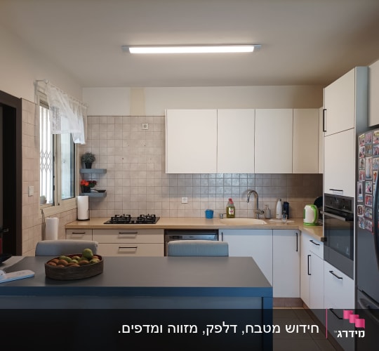 מטבח מודרני עם ארונות לבנים וכיור נירוסטה
